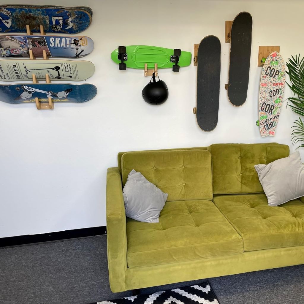 Wall-mounted bamboo rack for skateboards and snowboards with accessory hook.