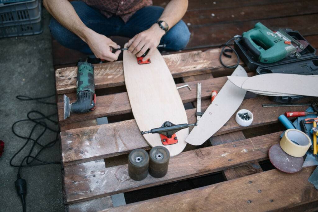 Skateboard bearings soaking in cleaning solution with a soft brush nearby