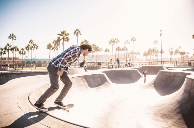Skateboarder holding a bamboo deck known for more pop and better durability than maple