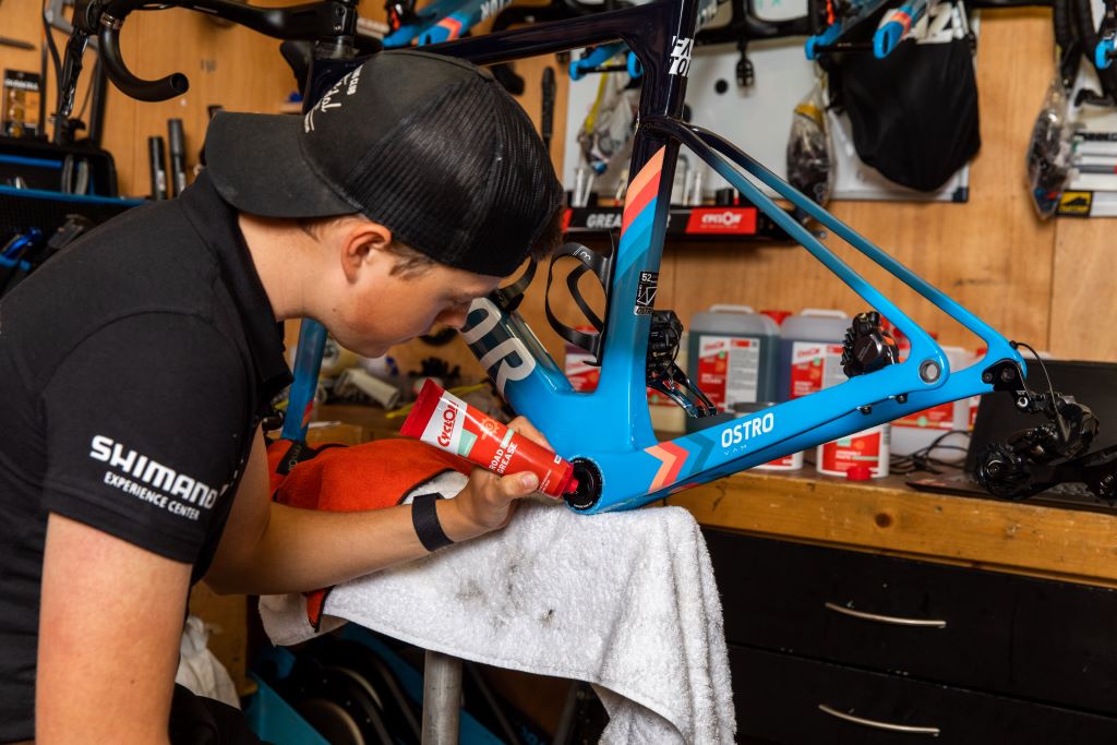 Applying bicycle grease to bike chain and moving parts for smooth maintenance